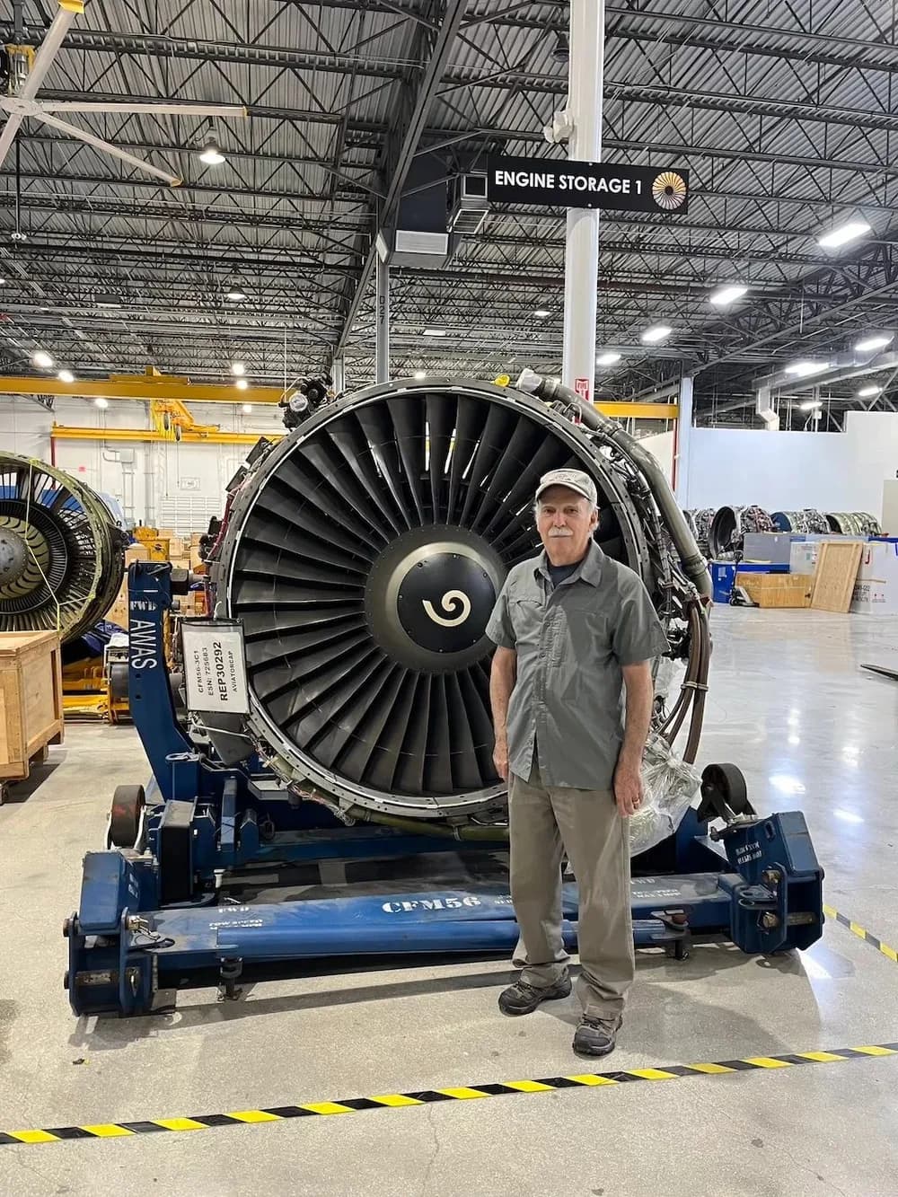 Standing with a CFM56 aircraft engine at an engine storage facility